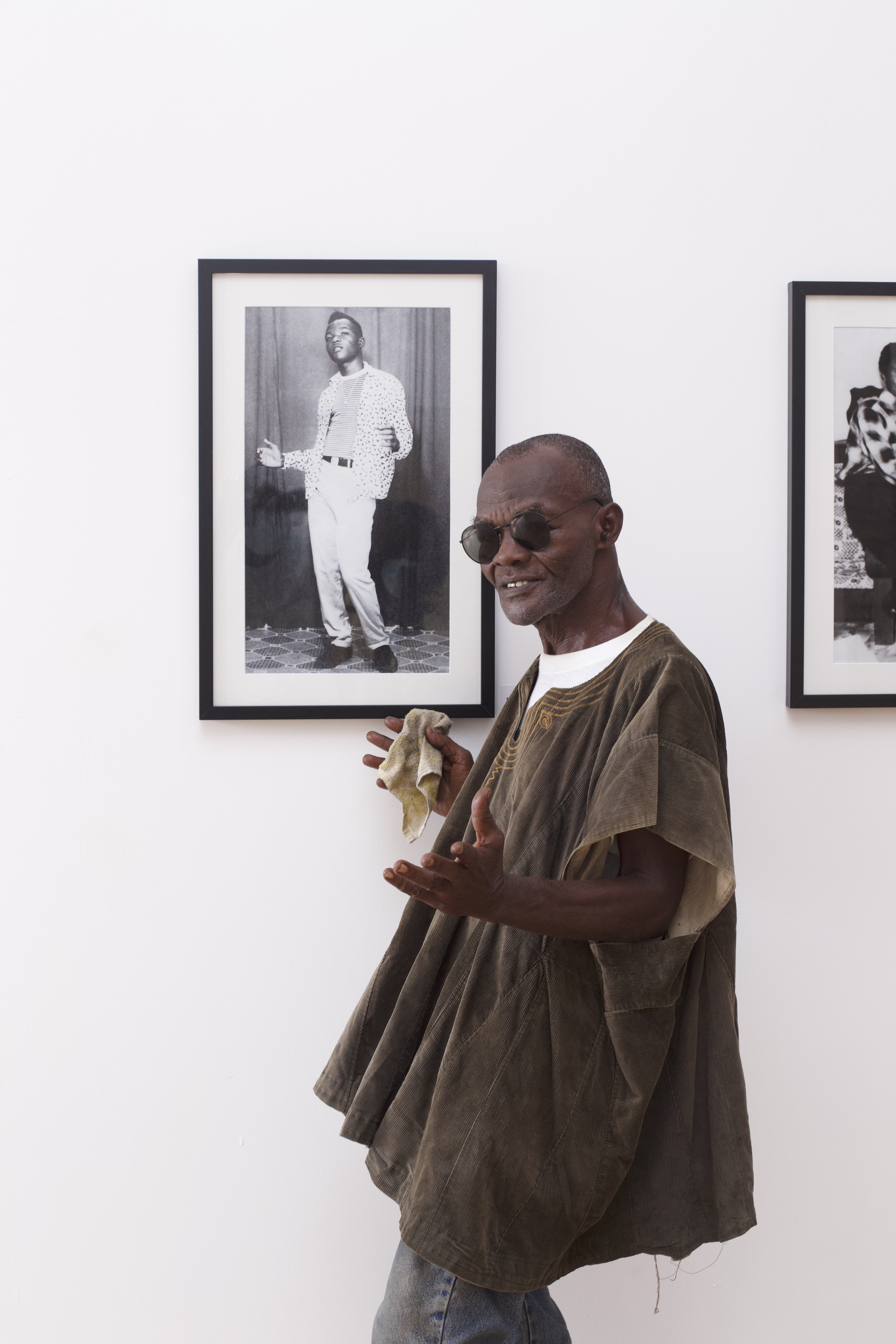 Nii Yemo Nunoo poses by a self-portrait, taken when he was 15 years old